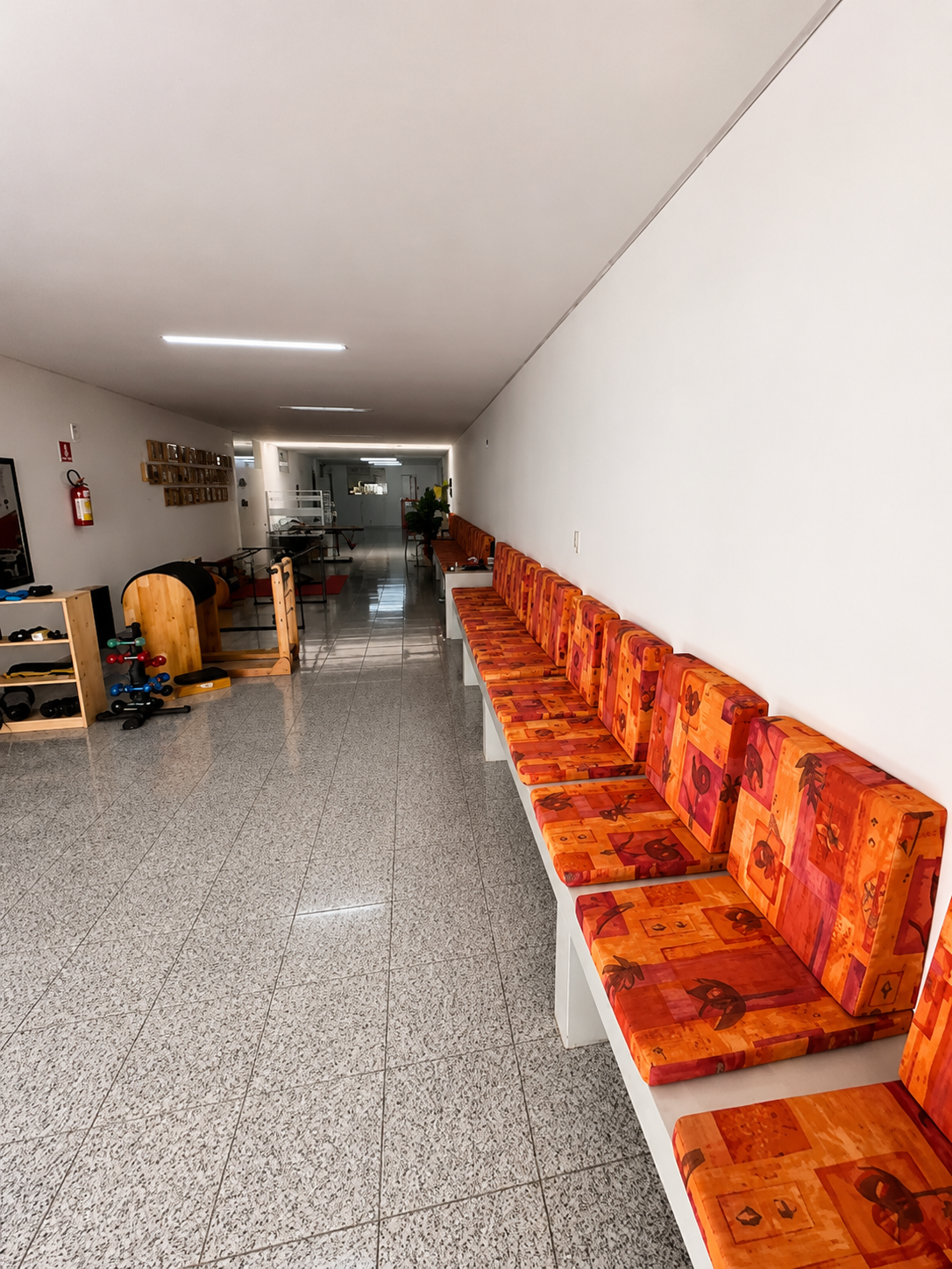 Corredor da clínica Corpo em Harmonia com área de espera e equipamentos de Pilates